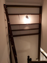 a ladder leading up to a shelf with a light on it