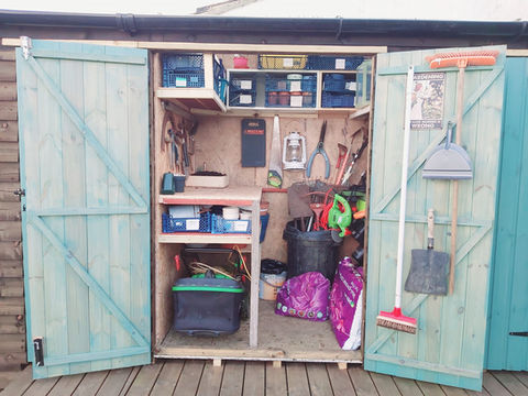 a shed with a sign that says gardening on it
