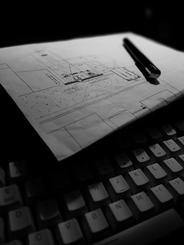 a pen rests on top of a drawing of a building