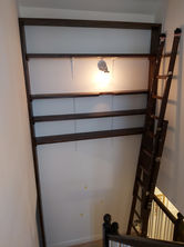 a ladder is attached to a wall next to shelves