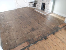 a wooden floor with a fireplace in the background