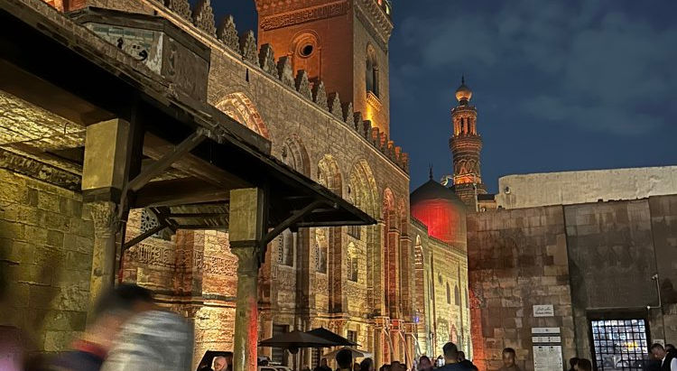 View of the Kan al Kallili souk in Cairo, Egypt, at night with bright red lighting accenting the ancient buildings