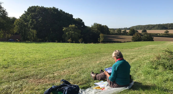 Walker sitting in field and planning a walk