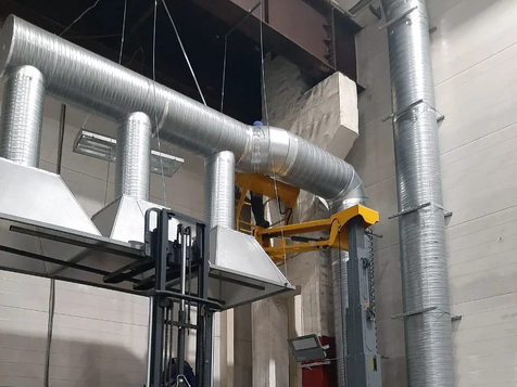 Silver ventilation pipes in a factory setting, machinery background, industrial design.