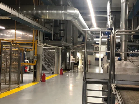 Factory interior with machinery and ventilation system, an industrial setting.