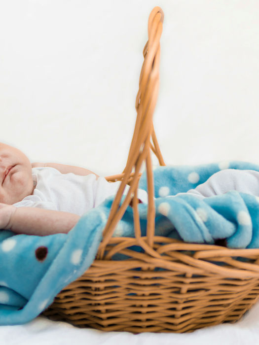 Sleeping newborn in wicker basket