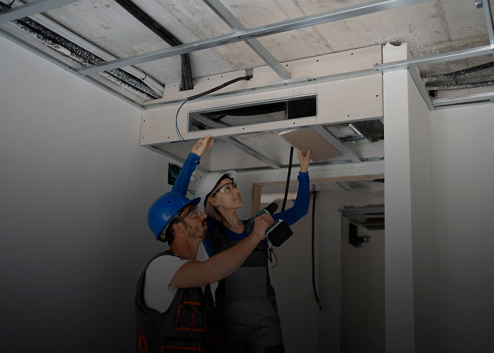 Contractors installing ceiling tiles during home renovation