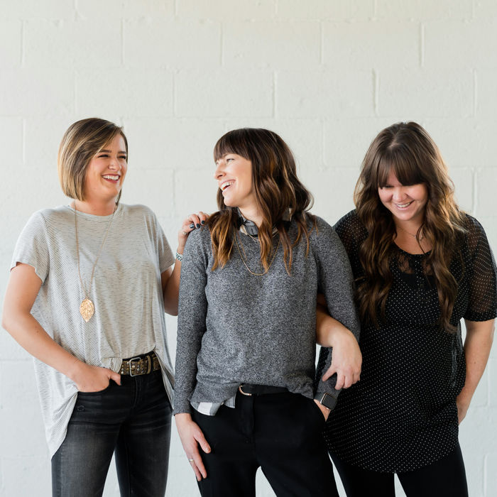 Three happy women laughing together, friends