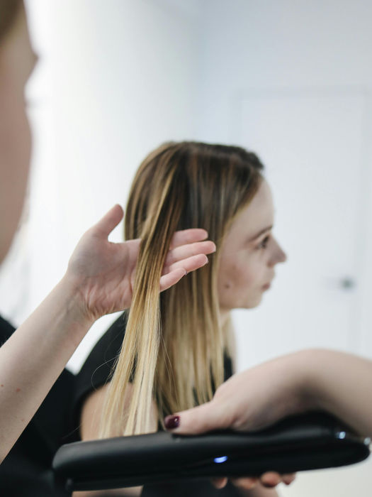 Stylist checking customer's blonde hair