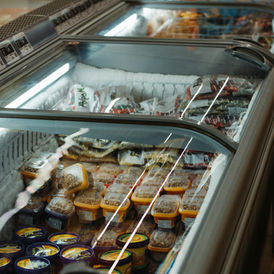 Commercial supermarket freezer stocked with frozen food products; contextual Unsplash image illustrating cold storage and packaging.