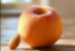 A peach and an almond in a table