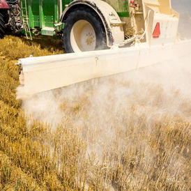 Tractor spreading agricultural limestone on farmland