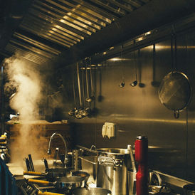 Stainless steel equipment and pans in a commercial kitchen, illustrating a restaurant food-handling environment.