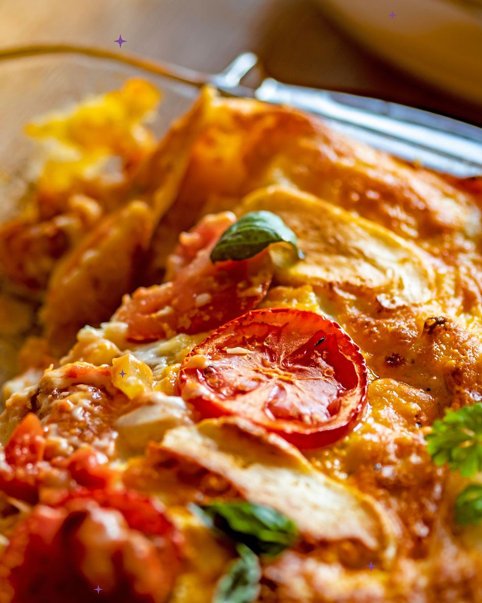 Large dish of lasagne with tomatoes and herbs on top