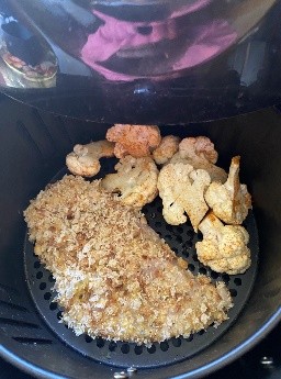 Chicken in breadcrumbs ready to be topped r with cauliflower