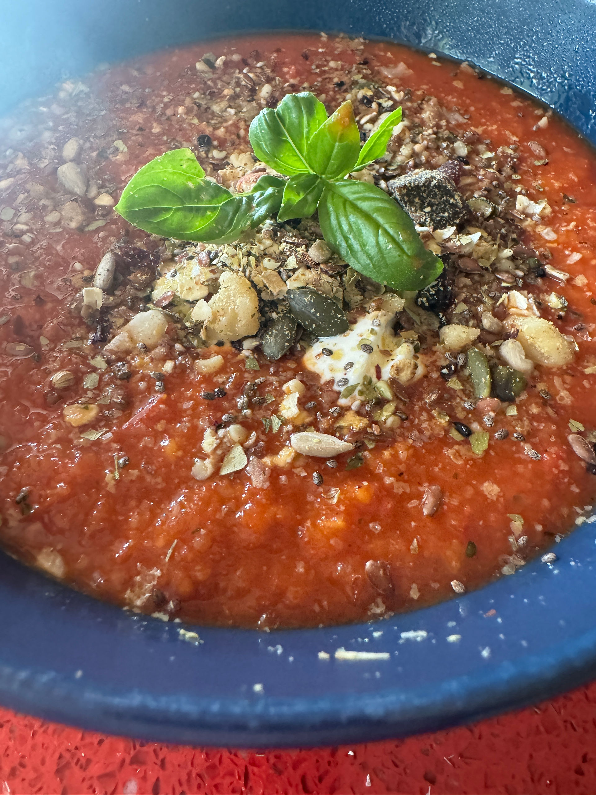 Bowl tomato soup with seeds and basil
