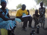 Pictured are Home Health Promoters Nhial and Rebecca meeting with villagers to diagnose and treat them.