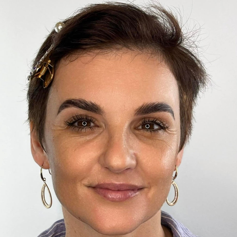 Woman with short hair and earrings smiles. Mugshot Makeup Artis