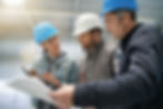The Facility Manager is showing building plans to workers