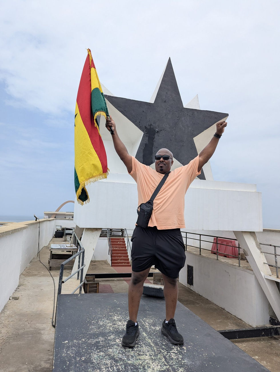 Visitor holding the Ghana flag at Black Star Square in Accra