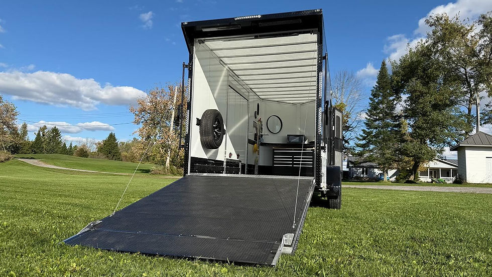 Close-up view of a trailer ramp and tie-down points inside an enclosed trailer.