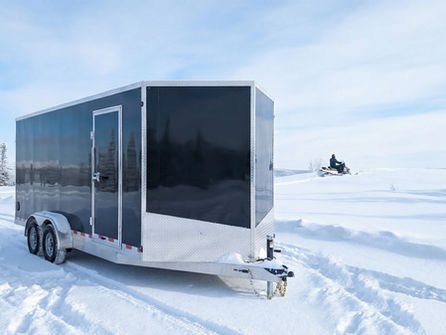 A black cargo trailer in a snowy Canadian landscape