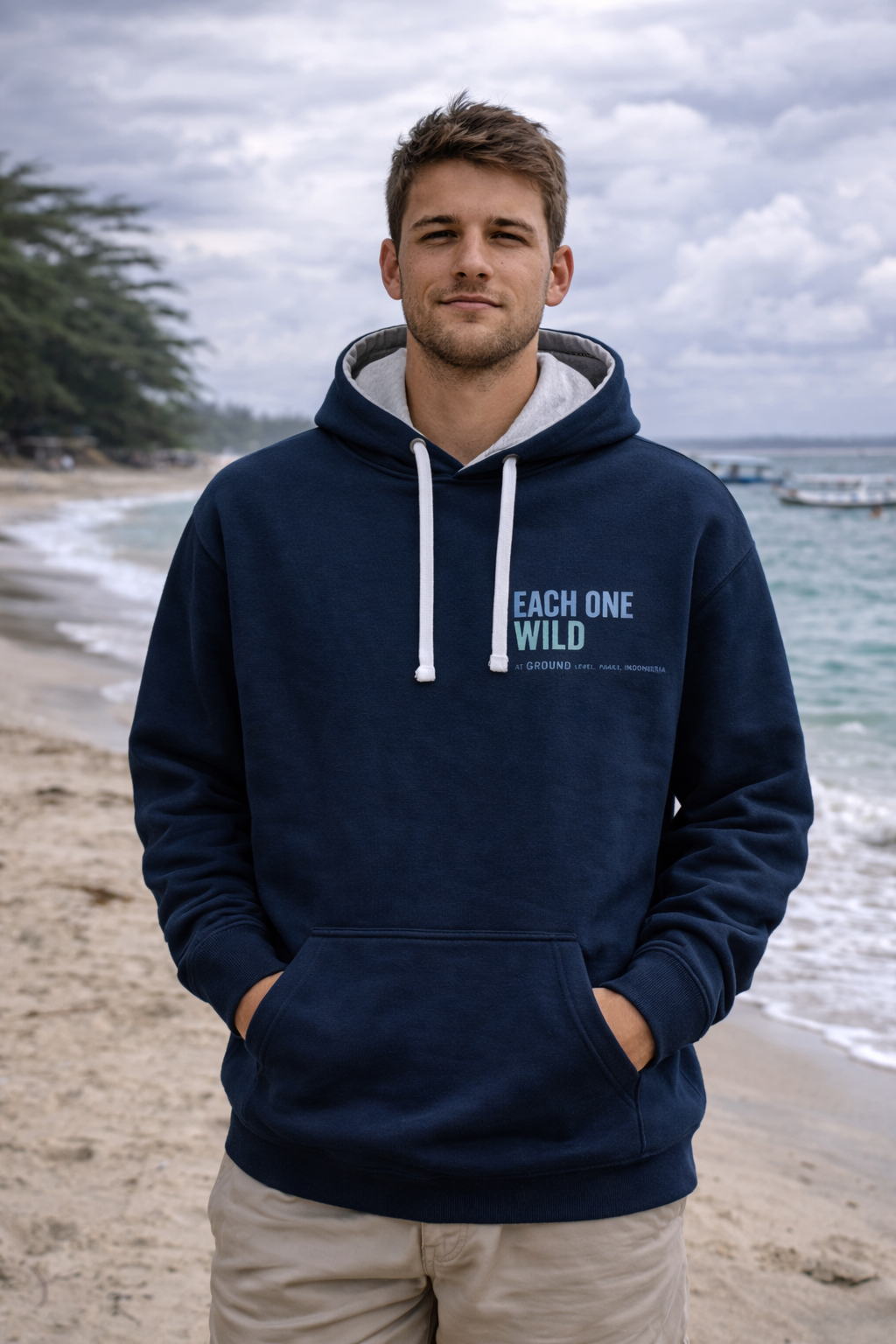Male on the beach wearing blue hoodie