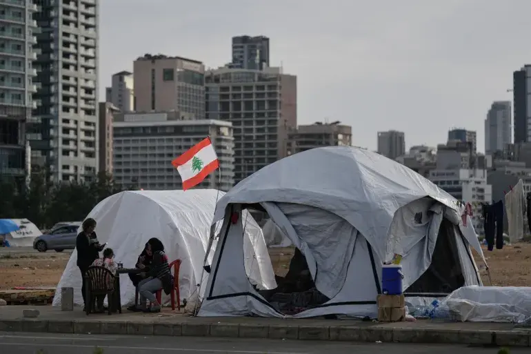Displaced people who fled Israeli strikes in southern Lebanon sit outside shelter tents in Beirut, Lebanon, on April 24, 2026 [Bilal Hussein/AP Photo]