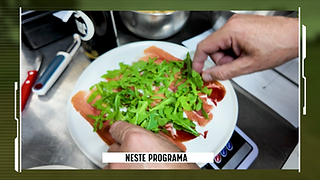 Prato com fatias de presunto e rúcula. Mãos parecem estar a preparar o prato.