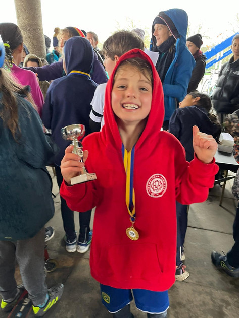 Image of a QPH junior boy with a running trophy