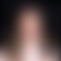 Elle Rustique smiling in front of a professional backdrop