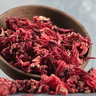 Dried hibiscus petals in a wooden bowl