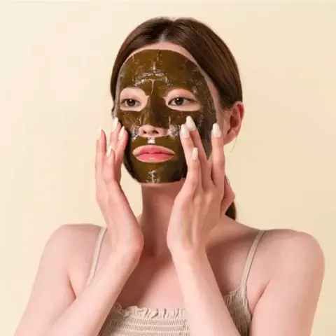 Femme appliquant un masque visage