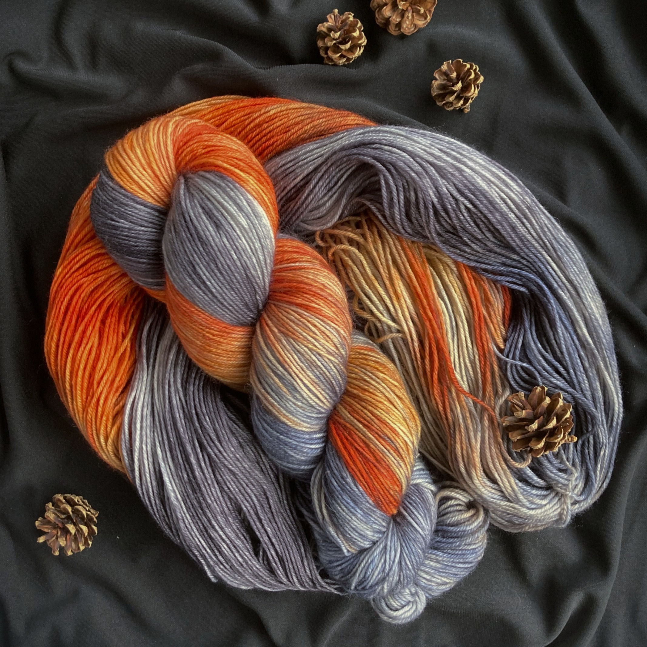 Hand dyed yarn. 75% gray, 25% rich orange with a bit of white seeing through.