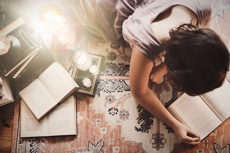 woman in white t-shirt lying on floor with books and photos_edited_edited.jpg
