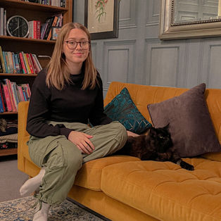 Girl and a cat on a sofa.