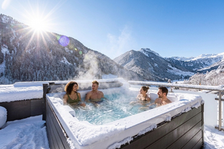 Im ganzjährig beheizten Whirlpool entspannen und den Blick auf die verschneite Bergwelt genießen. Boutique Appartements in ruhiger Lage, ideal für Skitage im Skicircus Saalbach-Hinterglemm.