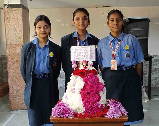 Students displaying flower arrangement artwork at St. Sebastian's School annual creative event Kolkata