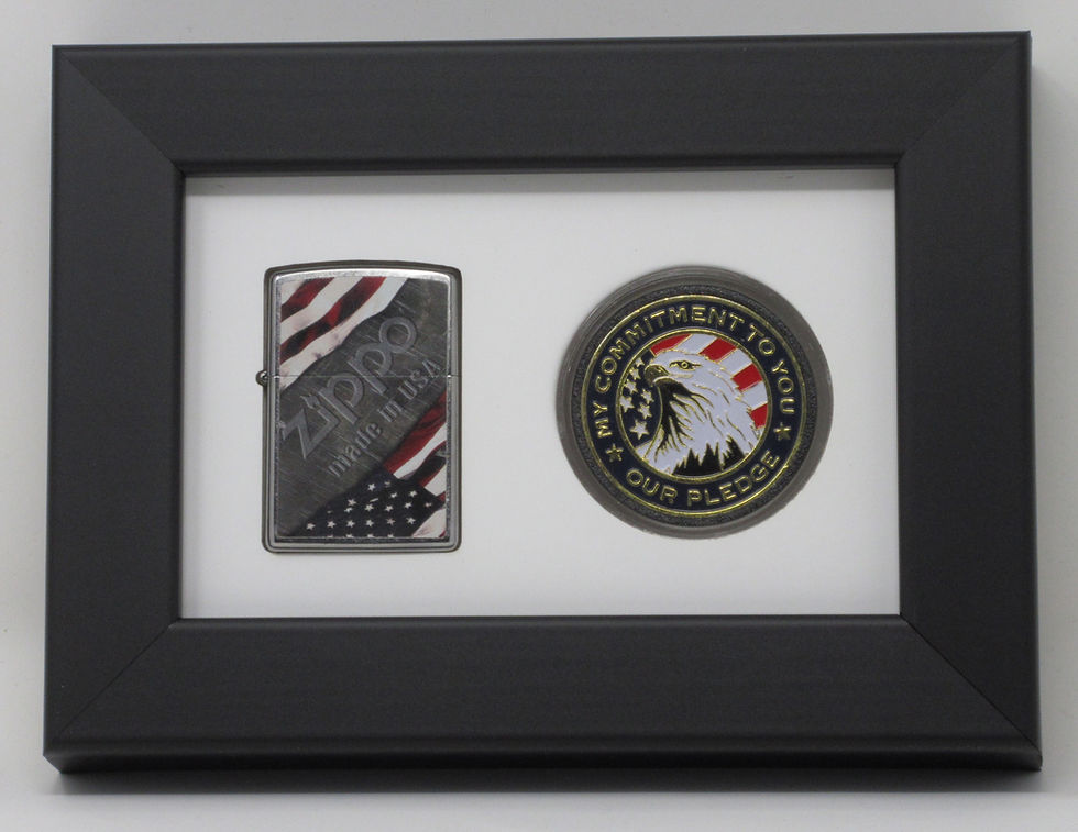 Framed Zippo lighter and military challenge coin. The lighter shows a flag and "Zippo, Made in U.S.A." The coin depicts an eagle with "My Commitment to You, Our Pledge."