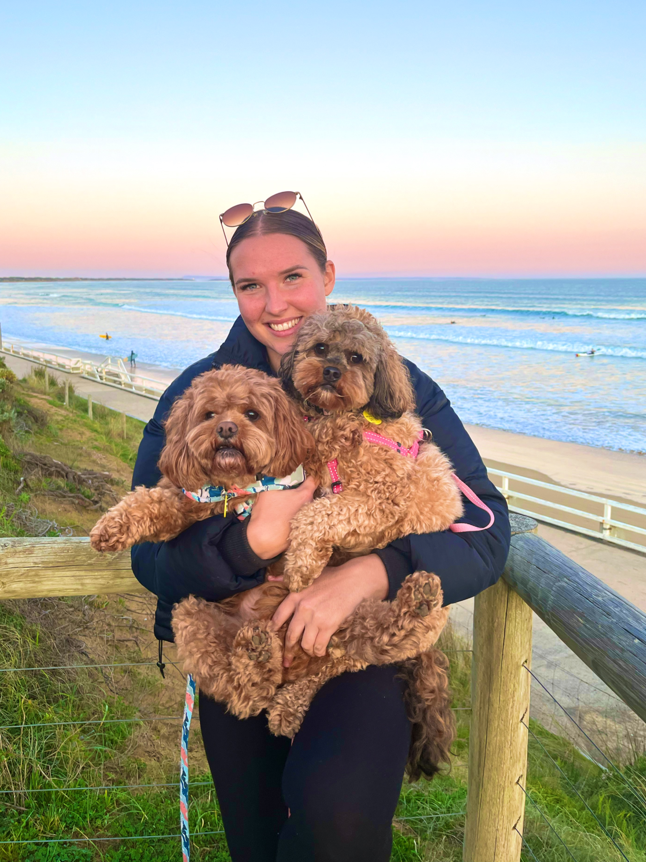 Paws & Purr founder Molly holding a dog at the coast.