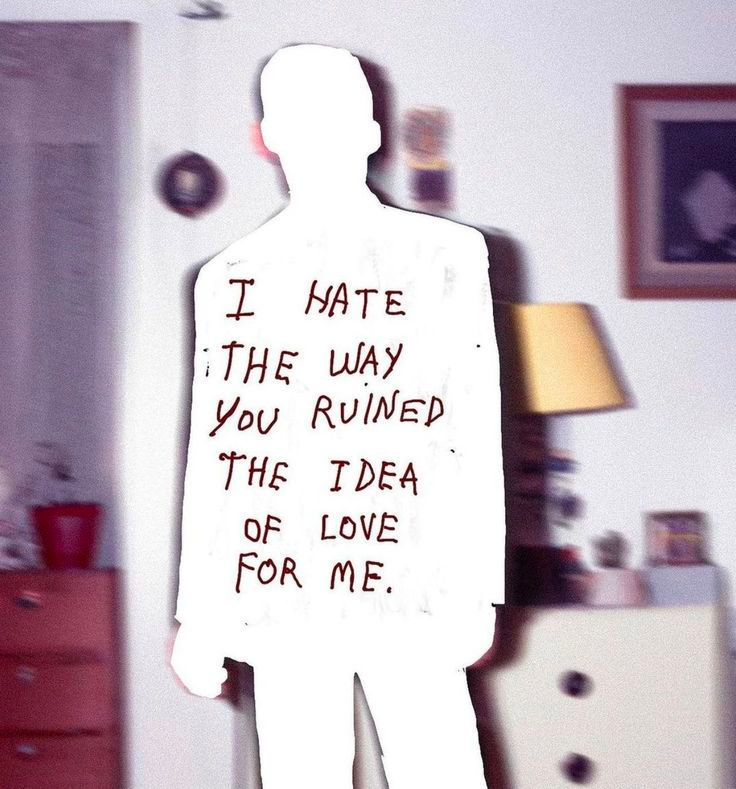 Silhouette with red text "I hate the way you ruined the idea of love for me" on a blurred room background with furniture and decor.