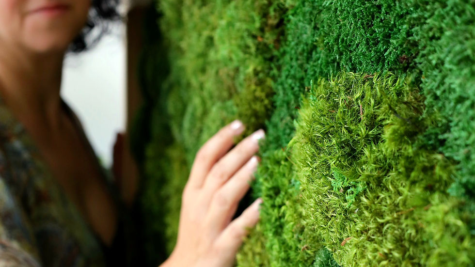 Paola Di Legge moss artist touching her moss art frame