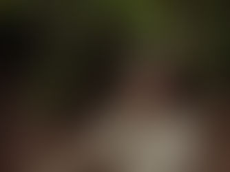 paola in the woods looking at a fern