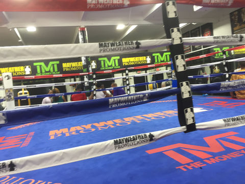 Floyd Mayweather promotional signage on ropes of boxing ring and on a blue floor