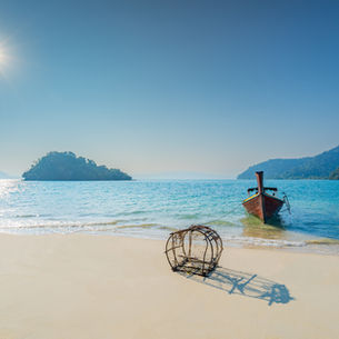 Longtailboot an einem einsamen Sandstrand im Koh-Kam-Archipel nördlich von Khao Lak