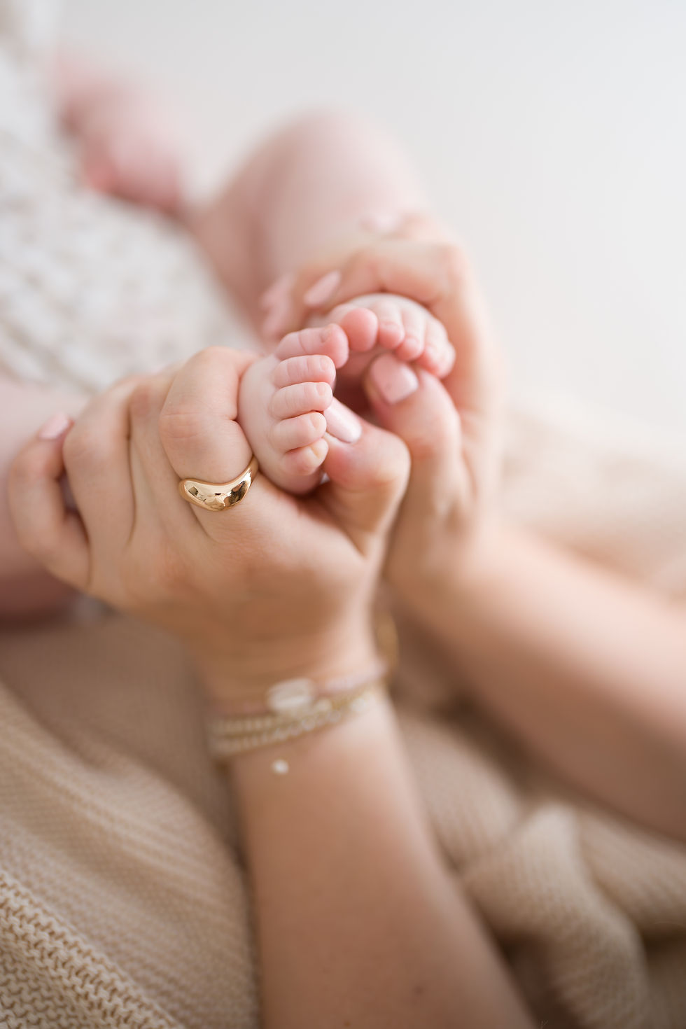 A mum holding her babies feet