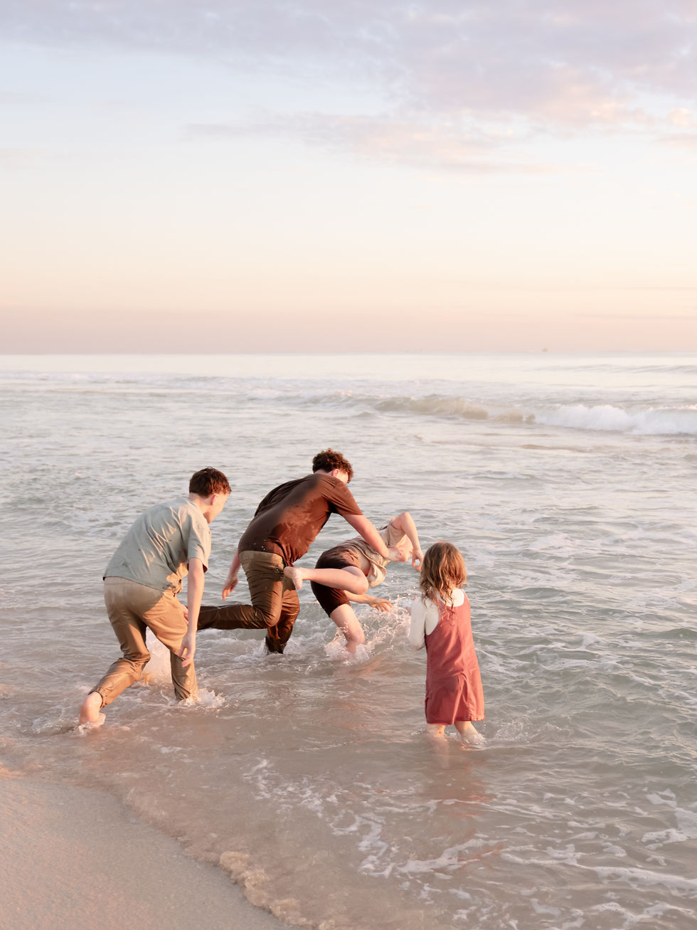 Children play in the ocean During their family photoshoot in Perth
