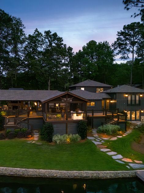 Lakeside house with illuminated decks and dock at night
