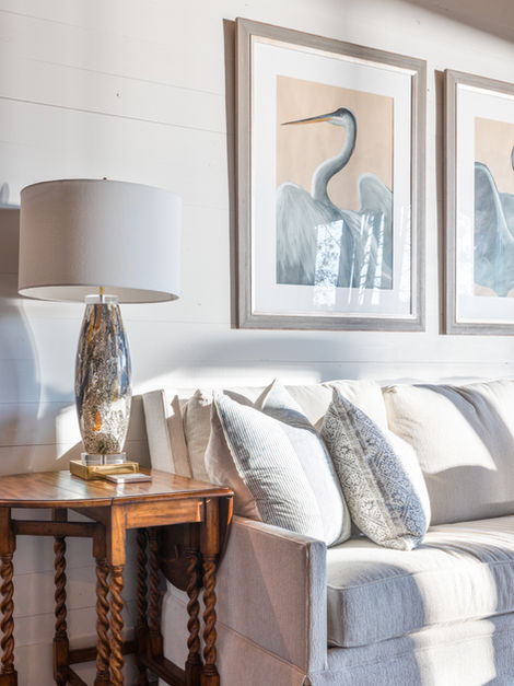 Cozy living room with sofa, lamp, and framed bird artwork