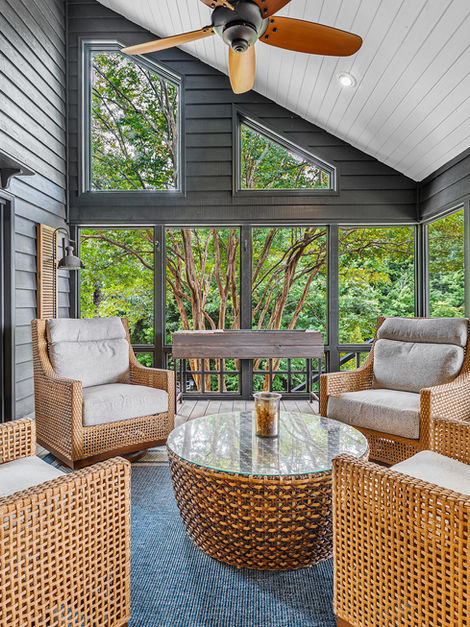 Cozy screened porch with wicker chairs and glass table